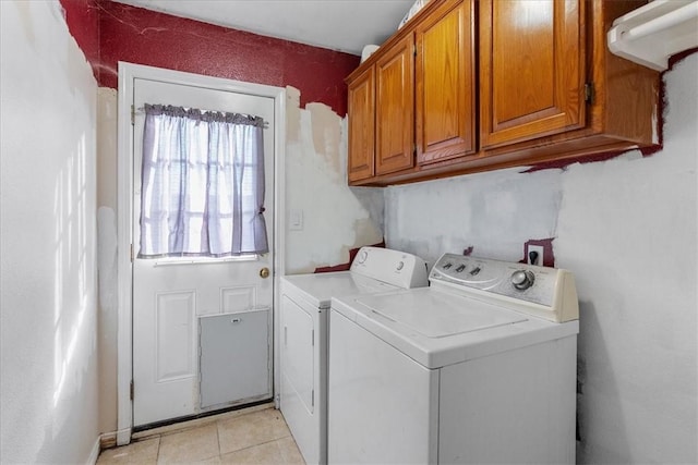 laundry room featuring cabinet space, light tile patterned floors, and washing machine and clothes dryer