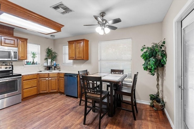 kitchen featuring dark wood-style floors, stainless steel appliances, light countertops, visible vents, and baseboards