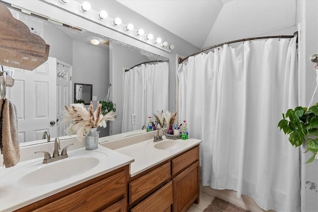 full bath featuring lofted ceiling, double vanity, tile patterned flooring, and a sink