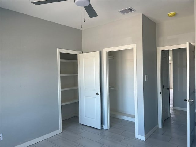 unfurnished bedroom with baseboards, visible vents, ceiling fan, and a closet