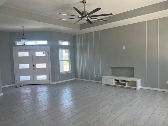 foyer entrance with light wood finished floors, baseboards, a ceiling fan, and french doors