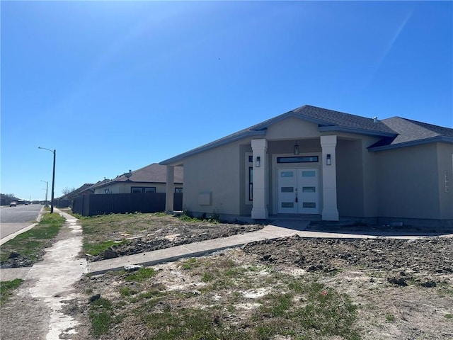 view of front of house with fence and stucco siding