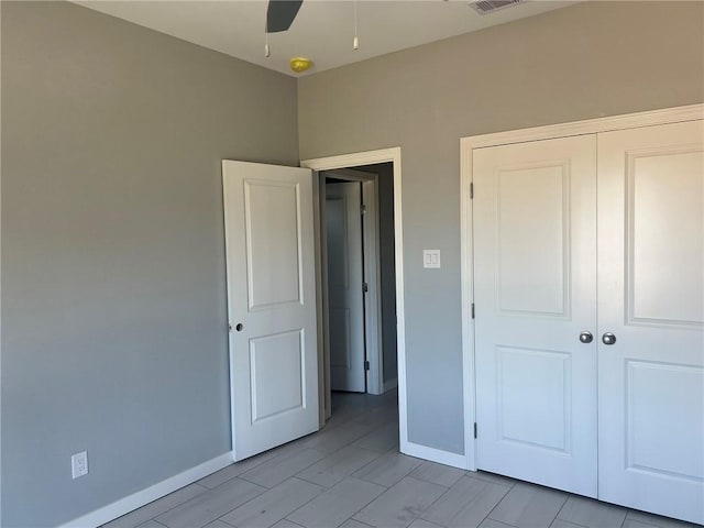 unfurnished bedroom featuring a ceiling fan, a closet, visible vents, and baseboards