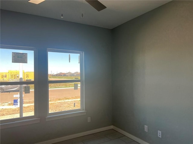 tiled spare room with ceiling fan, a wealth of natural light, and baseboards