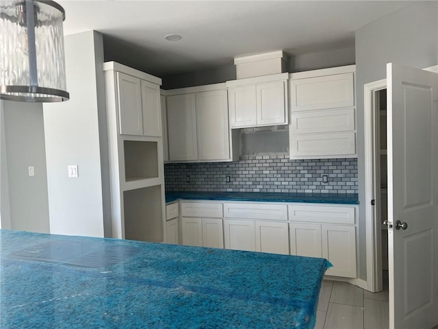 kitchen with dark countertops, white cabinetry, and decorative backsplash