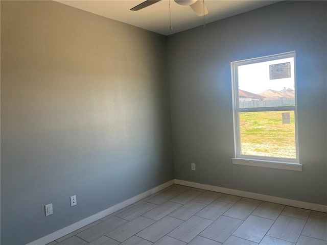 unfurnished room featuring a ceiling fan and baseboards