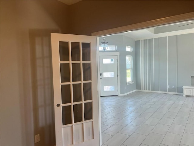 unfurnished room featuring baseboards and light tile patterned flooring