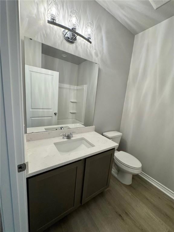 bathroom with hardwood / wood-style floors, toilet, and vanity