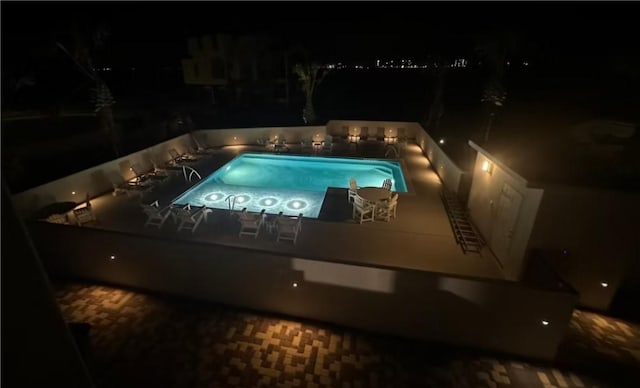 view of pool at twilight