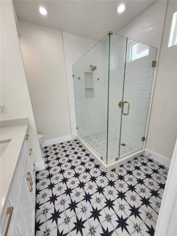 full bath featuring tile patterned floors, vanity, a shower stall, and baseboards