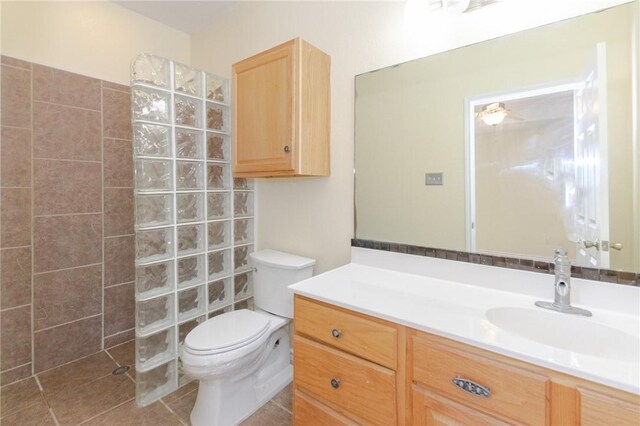 bathroom with walk in shower, tile patterned flooring, vanity, and toilet