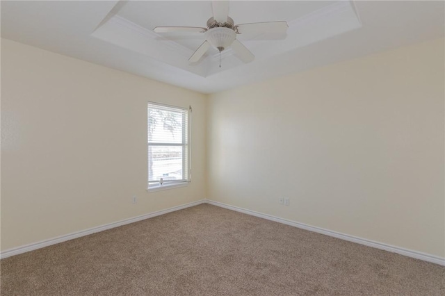 carpeted empty room featuring a tray ceiling and ceiling fan