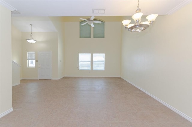 unfurnished room with ornamental molding, ceiling fan with notable chandelier, a healthy amount of sunlight, and light tile patterned flooring