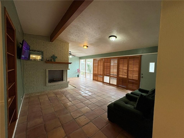 living room featuring brick wall, a fireplace, vaulted ceiling with beams, ceiling fan, and a textured ceiling