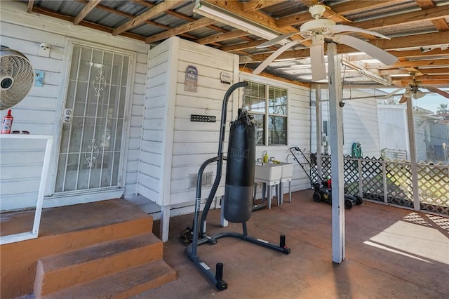 workout room featuring wooden walls and ceiling fan