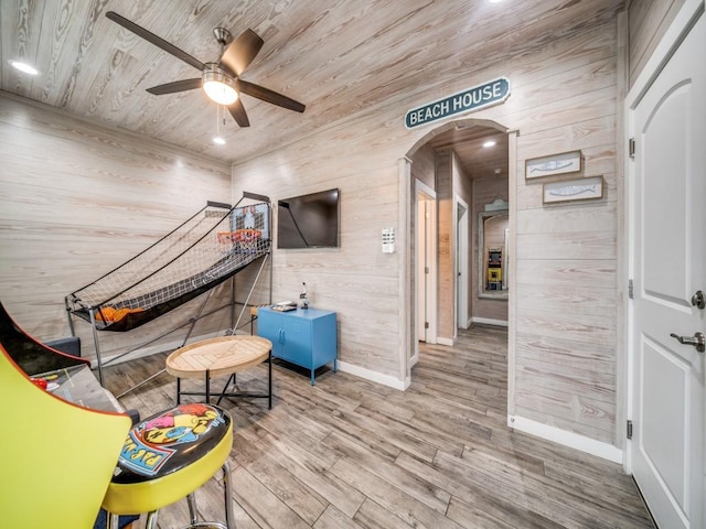 playroom featuring ceiling fan, wooden ceiling, wood-type flooring, and wood walls