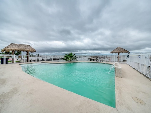 view of pool featuring a water view, pool water feature, a gazebo, and a patio