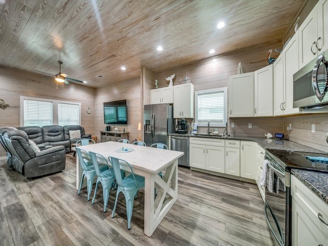 kitchen with dark stone countertops, sink, stainless steel appliances, white cabinets, and wooden ceiling