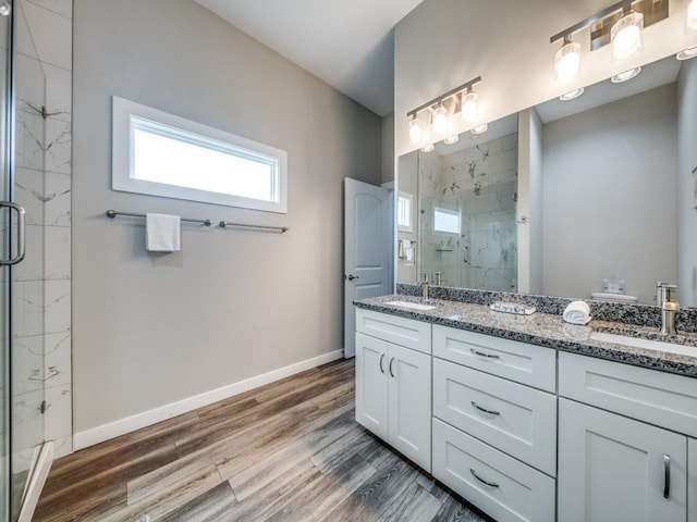 bathroom with a shower with shower door, vanity, and hardwood / wood-style flooring