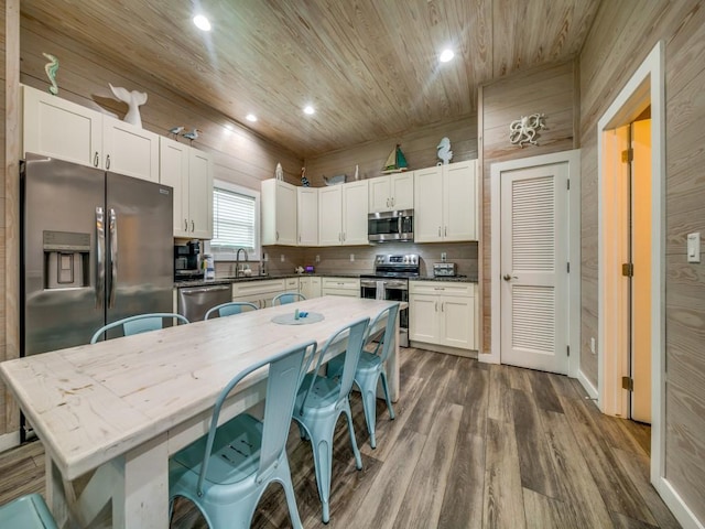 kitchen featuring dark wood-type flooring, white cabinetry, appliances with stainless steel finishes, and wood ceiling