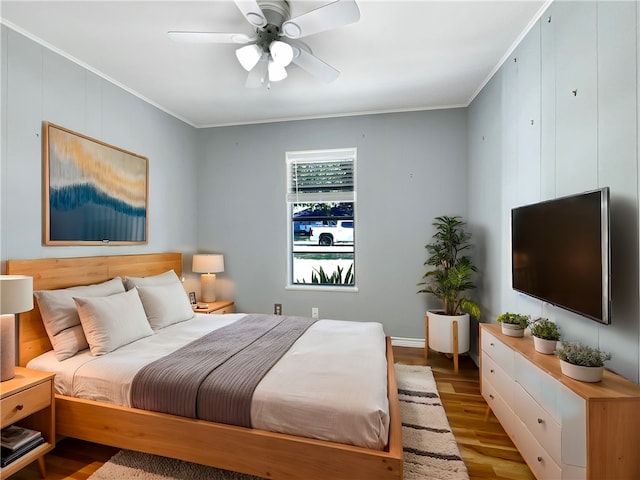 bedroom featuring ornamental molding, wood-type flooring, and ceiling fan