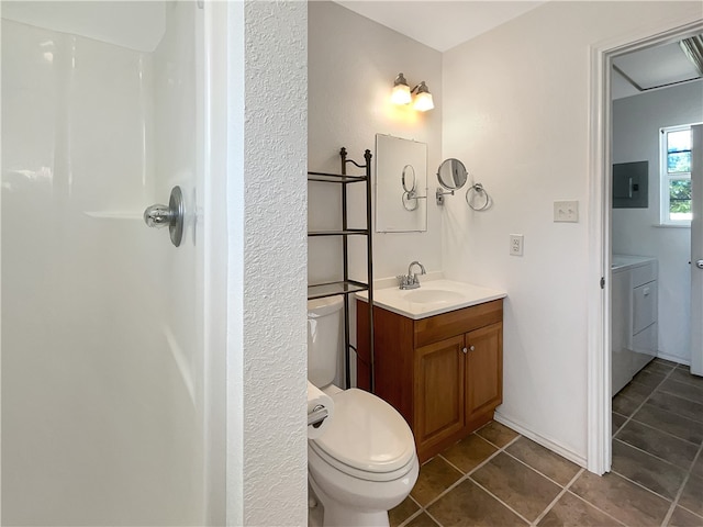 bathroom with electric panel, washer / dryer, vanity, tile patterned flooring, and toilet