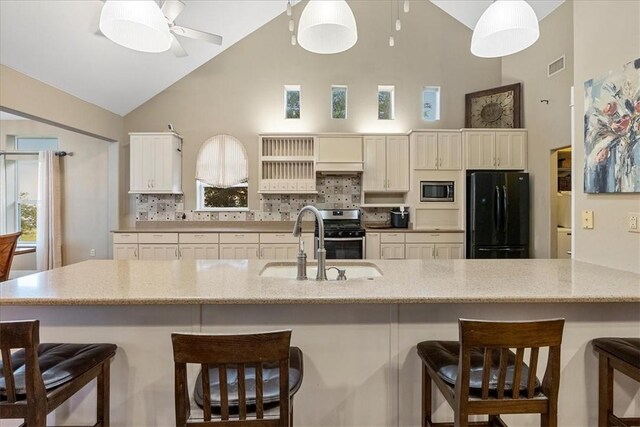 24475 La Ponderosa Dr, Mathis, TX 78368 - kitchen featuring stainless steel appliances, high vaulted ceiling, backsplash, a ceiling fan, and light stone counters