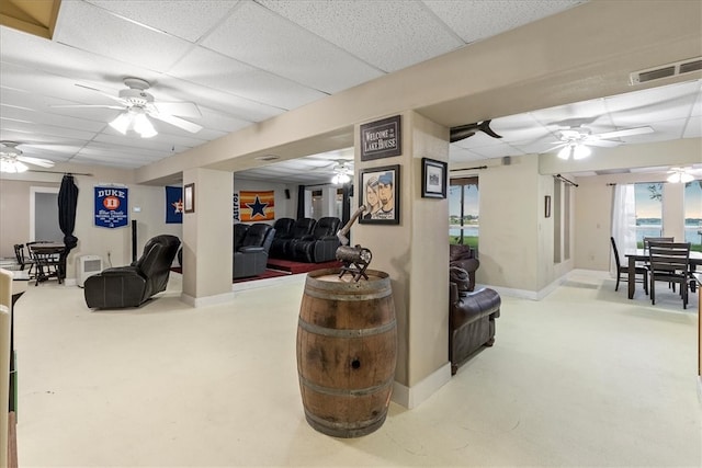 living room with concrete flooring and a paneled ceiling