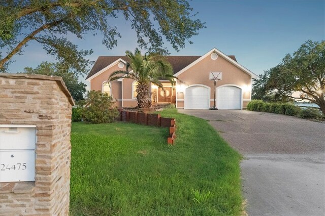 24475 La Ponderosa Dr, Mathis, TX 78368 - view of front of home featuring an attached garage, a front yard, driveway, and stucco siding