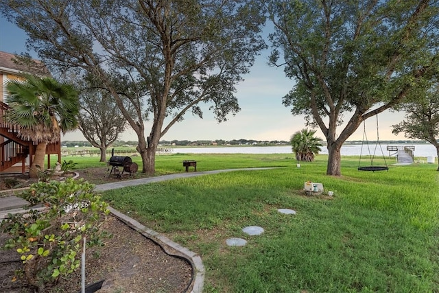 yard at dusk featuring a water view