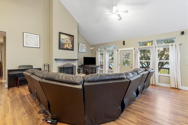 living room featuring light hardwood / wood-style floors, ceiling fan, and high vaulted ceiling