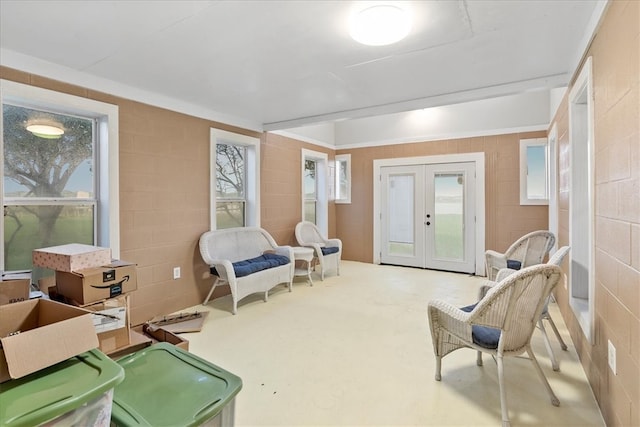 living area featuring concrete flooring and french doors