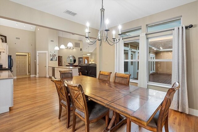 24475 La Ponderosa Dr, Mathis, TX 78368 - dining area featuring light wood-type flooring, a chandelier, and a high ceiling