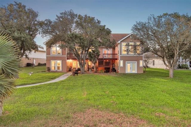 view of front of house with french doors, a front yard, and a deck