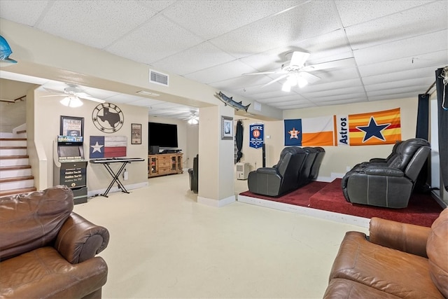 living room featuring a paneled ceiling, concrete floors, and ceiling fan