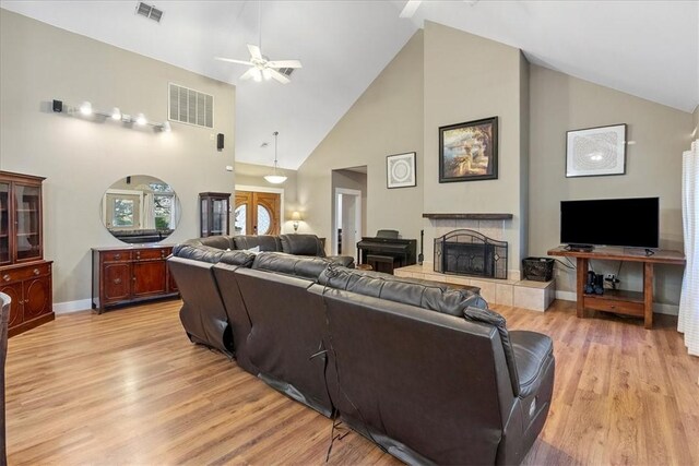 24475 La Ponderosa Dr, Mathis, TX 78368 - living room with high vaulted ceiling, a ceiling fan, a fireplace, and light wood-type flooring