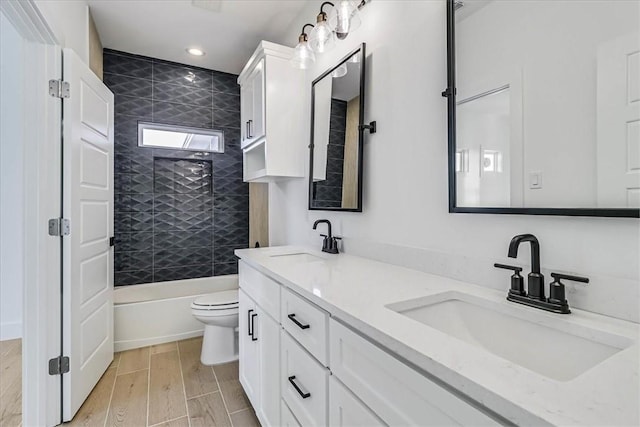 full bathroom with tiled shower / bath combo, vanity, and toilet