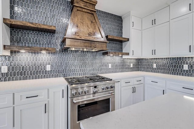 kitchen featuring white cabinetry, backsplash, high end stove, and premium range hood