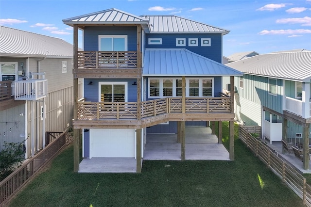 rear view of property featuring a balcony, a lawn, and a patio area