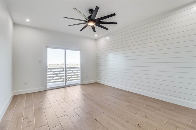 empty room with ceiling fan and light hardwood / wood-style floors