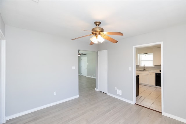 unfurnished room featuring light hardwood / wood-style floors, ceiling fan, and sink