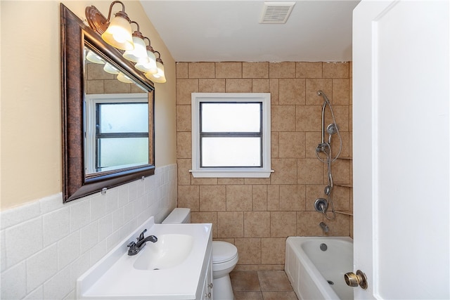 full bathroom featuring a wealth of natural light, tile patterned flooring, toilet, and tile walls