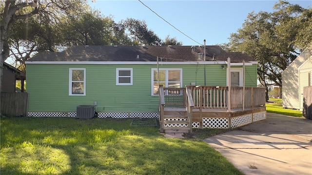 back of property with a deck, a lawn, and cooling unit