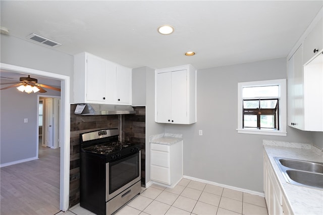 kitchen with sink, white cabinetry, stainless steel gas range, and ceiling fan