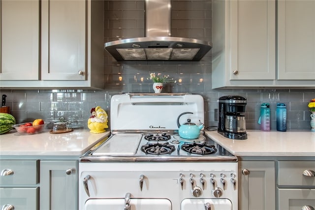 kitchen with tasteful backsplash, white range oven, and wall chimney range hood