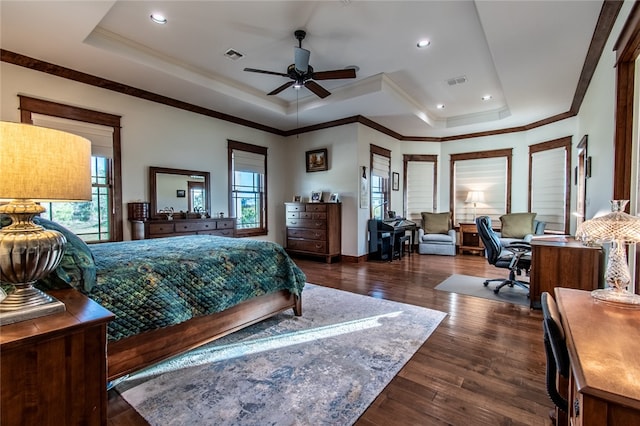 bedroom with dark hardwood / wood-style flooring, ornamental molding, a tray ceiling, and ceiling fan