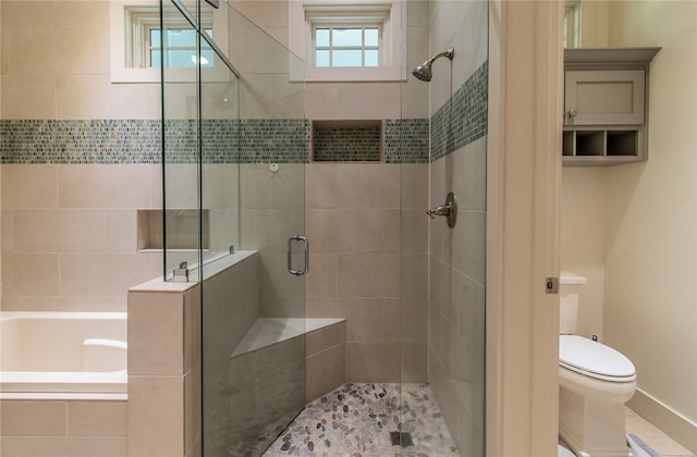 bathroom featuring plenty of natural light, toilet, and separate shower and tub