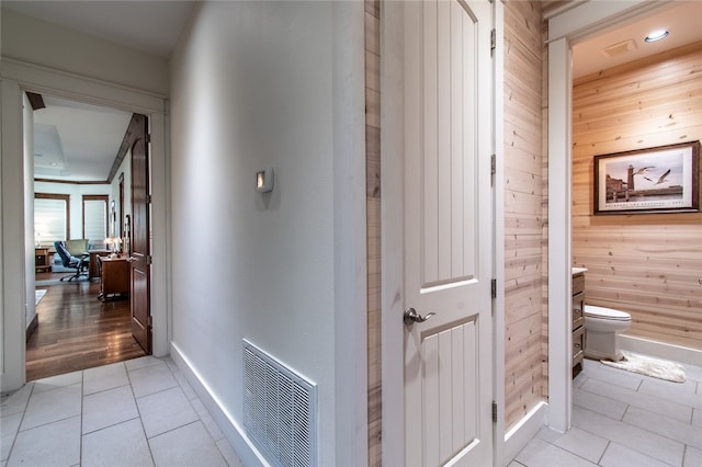 hallway featuring wood walls and light hardwood / wood-style floors