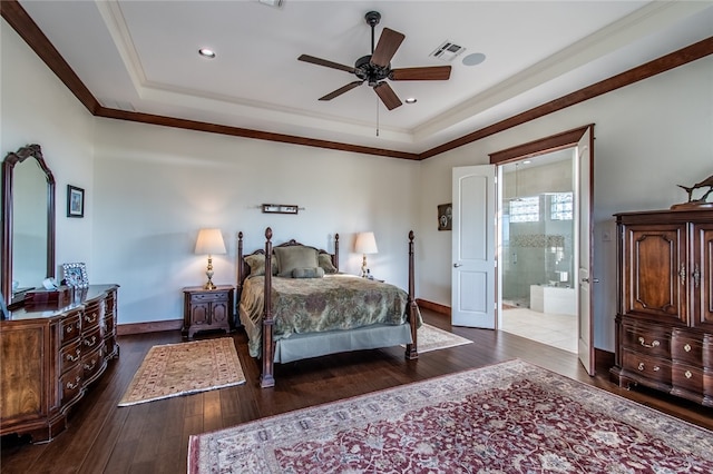 bedroom featuring crown molding, ensuite bath, a raised ceiling, dark hardwood / wood-style flooring, and ceiling fan