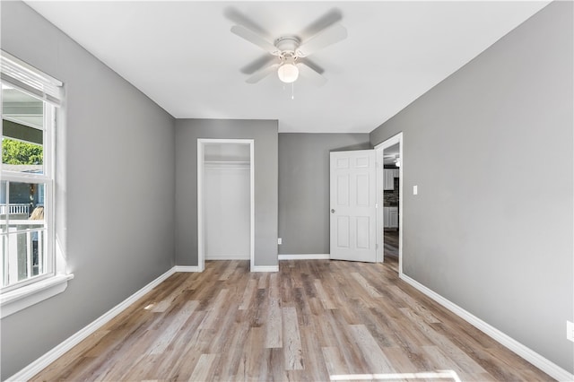 unfurnished bedroom featuring a closet, light hardwood / wood-style floors, and ceiling fan